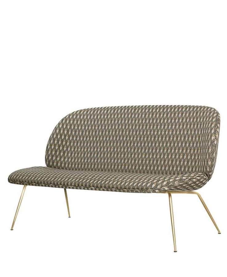 Gubi, Beetle Sofa – La célèbre chaise déclinée en sofa, habillé du tissu géométrique Pfauenauge de Backhausen coloris fauve. Piètement scarabée en laiton.
