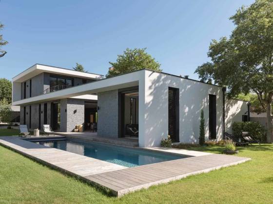 Cette maison contemporaine, réalisée par Naao Architecture, s’inscrit dans la linéarité horizontale et verticale, jouant sur les clairs-obscurs à l’extérieur comme à l’intérieur, en lien étroit avec le terrain exigu de 20 mètres de largeur.