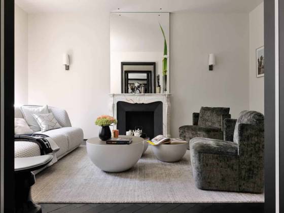 Le miroir rétro-éclairé a été imaginé comme un écho dialoguant directement avec la salle à manger. Canapé Redondo (Moroso). Tables basses Bongo et fauteuils Keeton (Meridiani). Tapis Toulemonde Bochart.