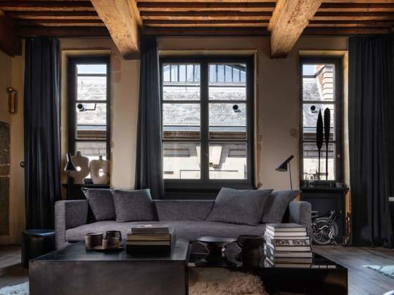 La pièce unique est privilégiée entre canapé dessiné par Maison Hand, meubles et objets chinés. Revêtement tissu et rideaux (Bisson Bruneel)