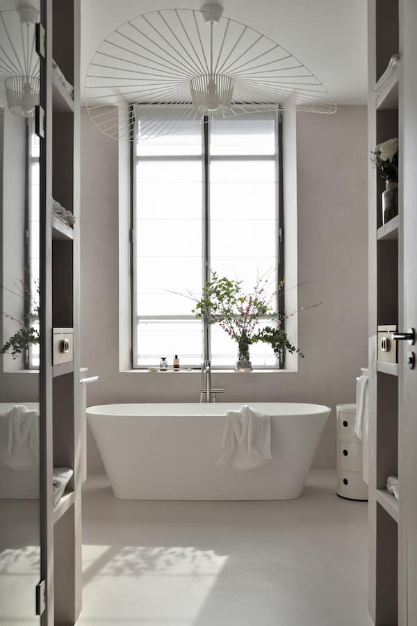 Au contact du béton légèrement rosé, la salle de bains, lie la chambre au dressing et témoigne de cette symétrie architecturale propre à l’ensemble du projet. Baignoire îlot de Victoria + Albert prône la détente. Poignées Gio Ponti, Olivari