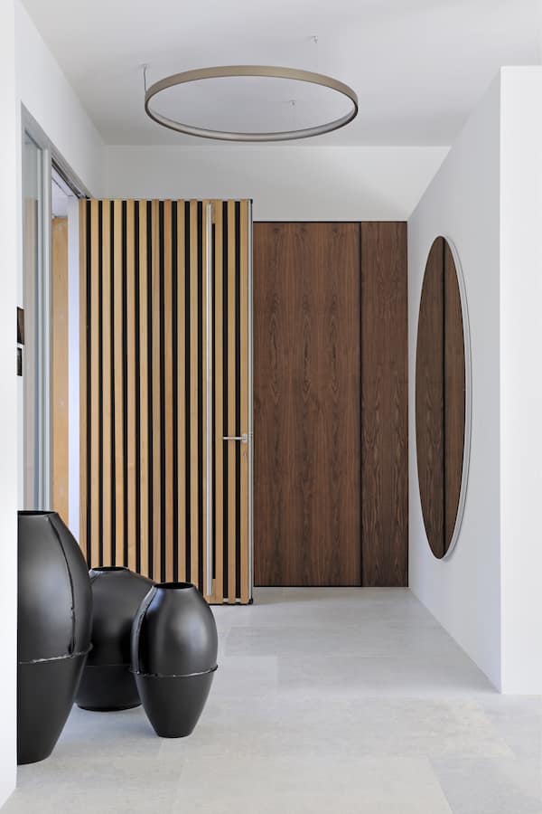 L’entrée donne le ton et les contours esthétiques minimalistes de l’architecture d’intérieur. Suspension, Delta Light. Miroir, Inbani