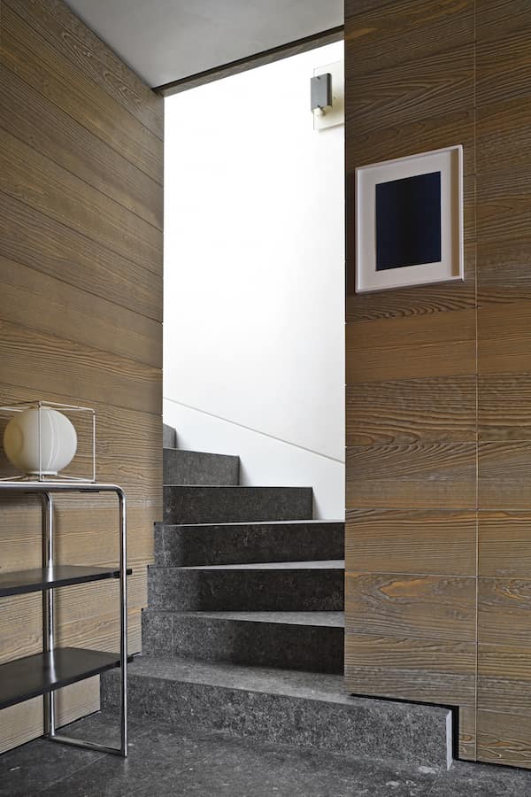 On suit le tracé architectural dans les moindres recoins, jusque dans l’escalier à crémaillère, statuﬁé par la pierre bleue du Hainaut. Étagère B 22 de l’architecte-designer Marcel Breuer. Tableau de l’artiste Irma Blank