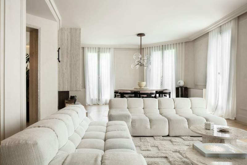 L’espace salle à manger dessiné par le canapé et la deuxième cheminée en travertin et marbre Calacatta s’inscrit comme une photographie en négatif
