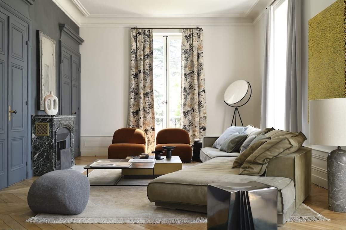Dans le salon, le mobilier choisi chez Claude Cartier. Tapis, CC-Tapis. Tables basses et canapé, Baxter. Fauteuils, Tacchini. Pouf, Moroso. Vase de Pierre Casenove sur la cheminée. Lampadaires, Flos et Gubi. Rideaux blancs, Dedar