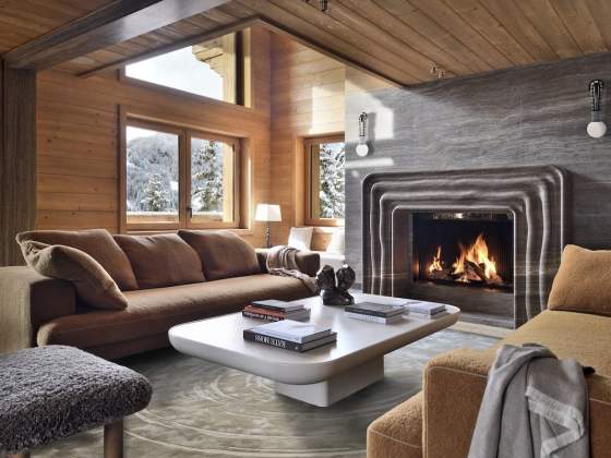 Les canapés Maxalto, la table en chaux minérale, la cheminée Y et le tapis (Maison Pinton) dessinés par Kelly, ainsi que les appliques d’Apparatus composent un décor chaleureux et raffiné