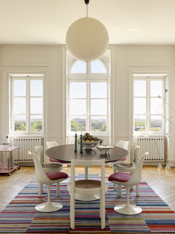 Un décor entre pièces chinées et mobilier contemporain. Table et chaises %22Tulip%22 (Knoll). Chaises vintage (De Baecque). Tapis kilim (Galerie Emir). Suspension %22Akari 55A%22 (Vitra). Luminaires %22Papiro%22 (Palluco). Centre de table %22Earth%22 (Serax).